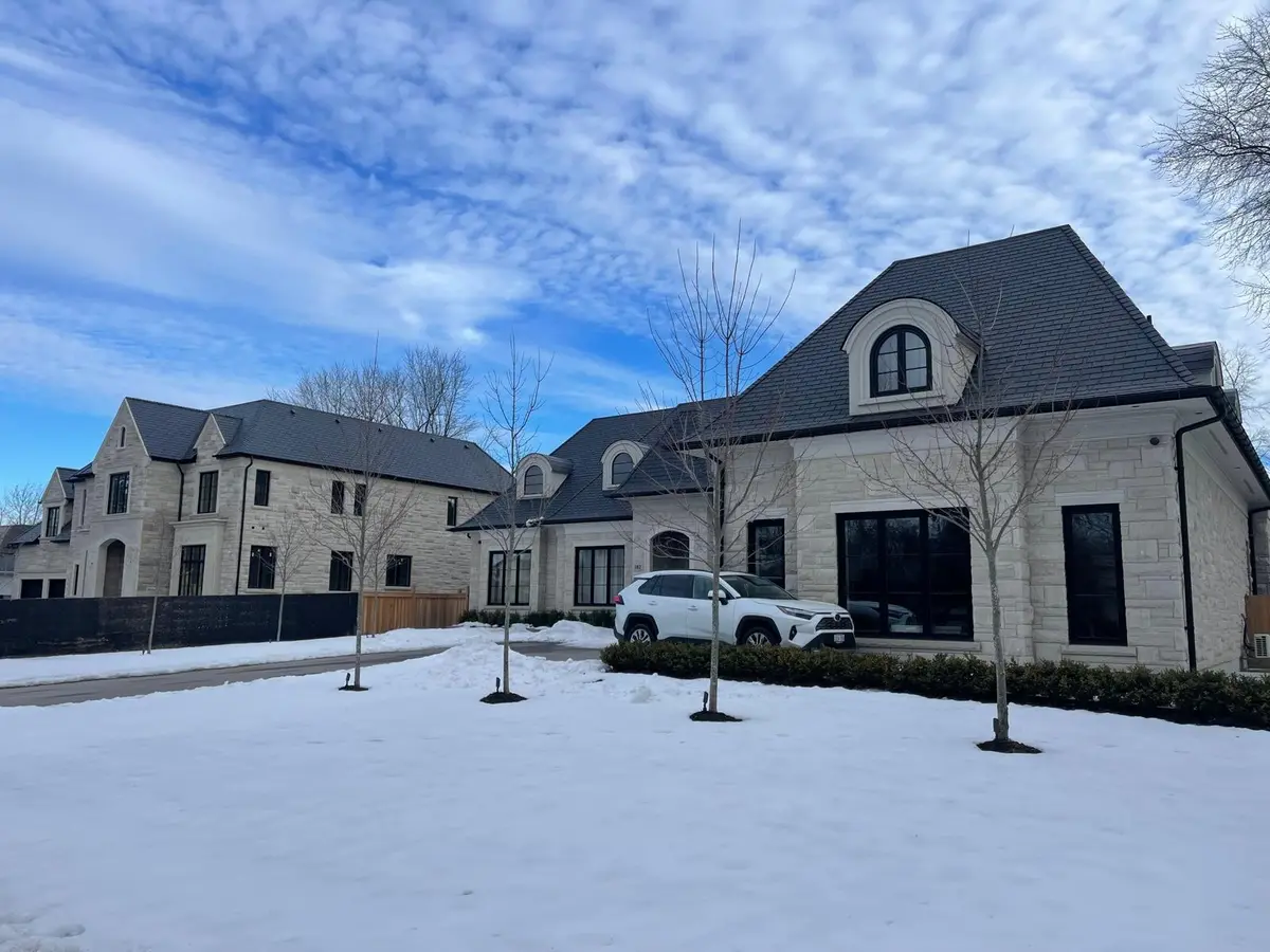 Stone estate home with a new dark roof in winter