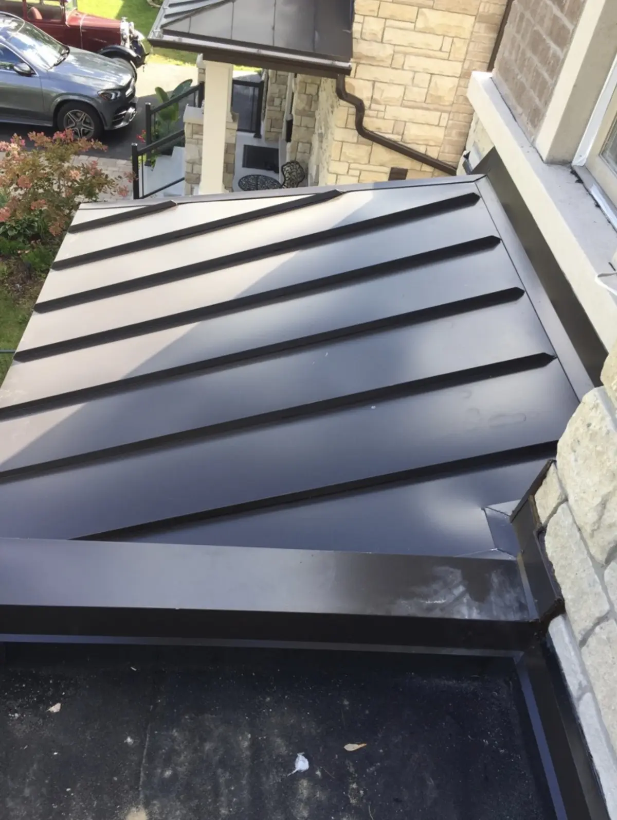 Dark standing seam metal roof over a front portico